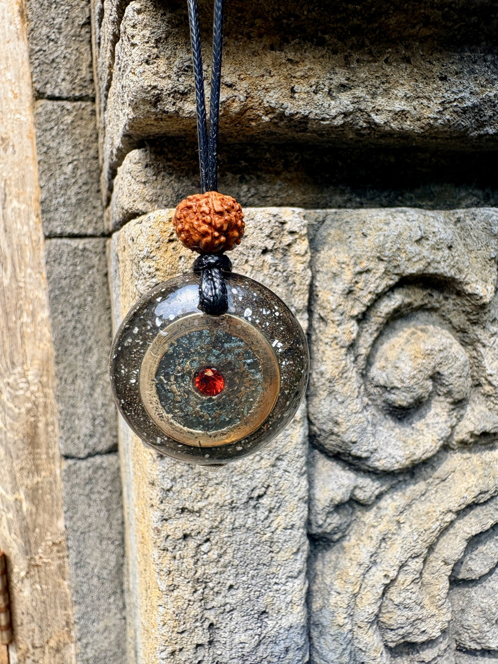 Bali Panca Datu Coin Pendant red garnet centre five sacred metals dark charcoal orgonite matrix rudraksha bead bail black cord Batuan Bali
