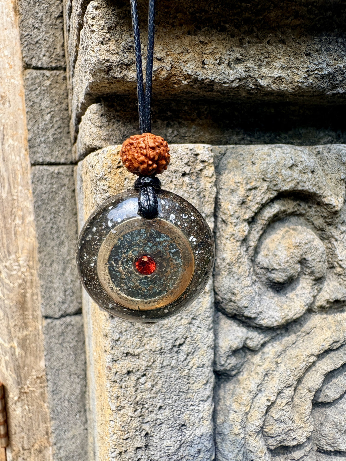 Bali Panca Datu Coin Pendant red garnet centre five sacred metals dark charcoal orgonite matrix rudraksha bead bail black cord Batuan Bali