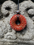 Large Red Jasper Torus Pendant copper spiral winding deep crimson red resin 48mm black braided cord mixed-stone bail bead Balinese stone wall Batuan Bali front view