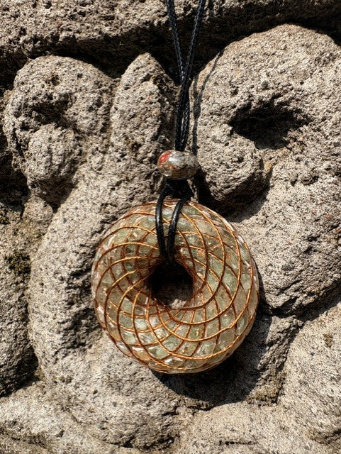 Large Green Aventurine Torus Pendant copper spiral winding warm golden green translucent resin 48mm black braided cord mixed-stone bail bead Balinese stone wall Batuan Bali front view