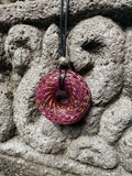 Large Purple Amethyst Torus Pendant copper spiral winding deep violet purple resin 48mm black braided cord mixed-stone bail bead Balinese stone wall Batuan Bali front view
