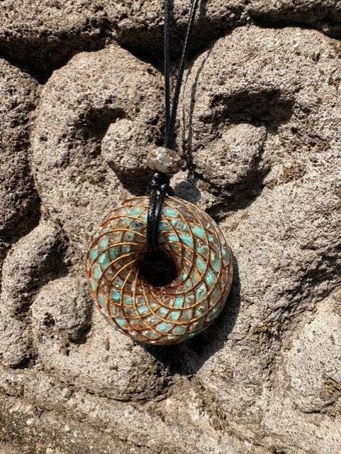 Large Turquoise Torus Pendant copper lattice diamond winding vivid blue green turquoise chips 48mm black braided cord mixed-stone bail bead Balinese stone wall Batuan Bali front view