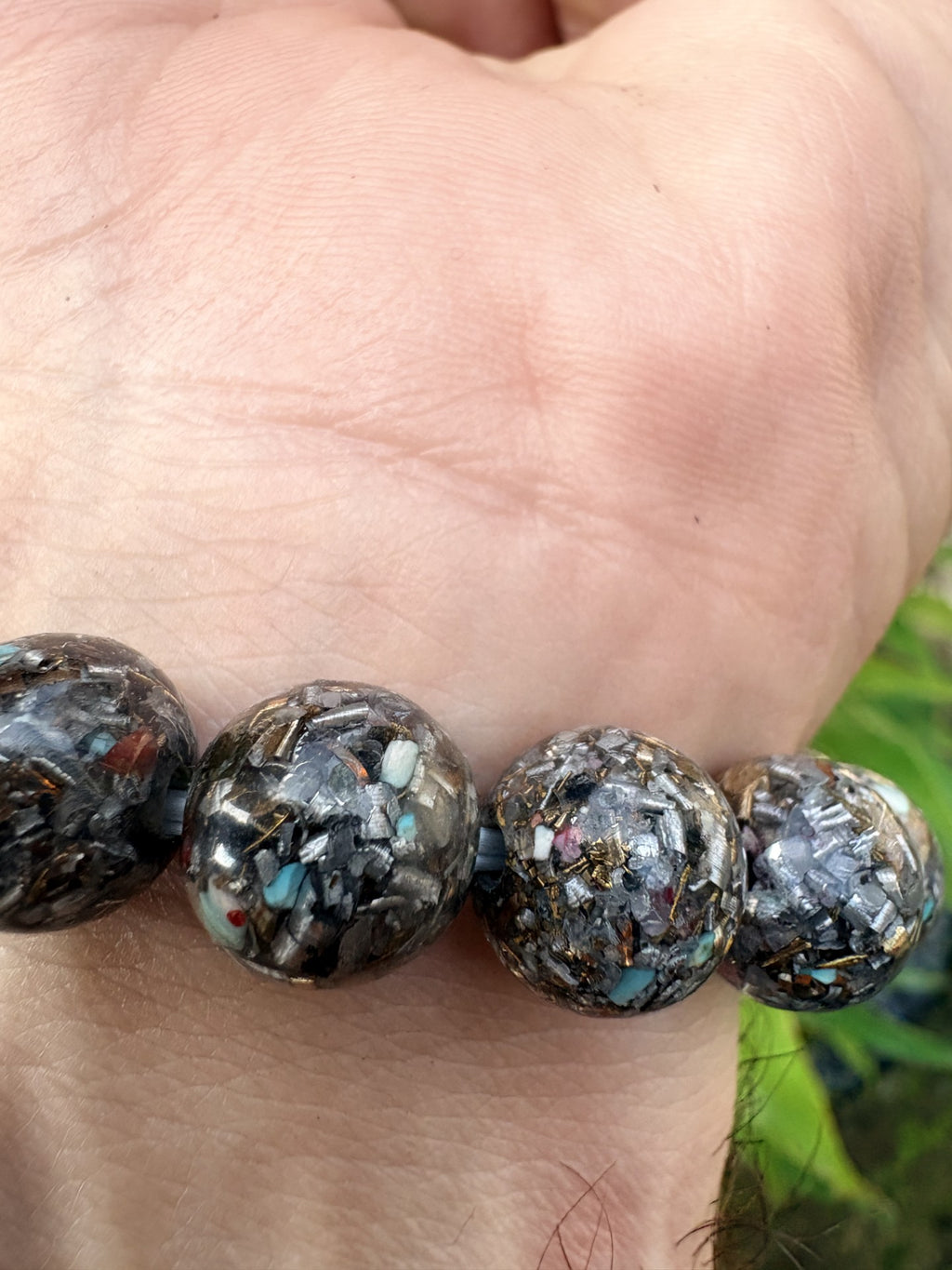 Seven Chakra Orgonite Bracelet close-up 15 mixed stone orgonite beads Turquoise Red Jasper Black Tourmaline Shungite gold leaf metal shavings clear resin Batuan Bali