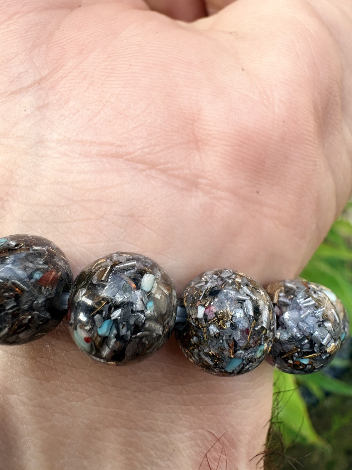 Seven Chakra Orgonite Bracelet close-up 15 mixed stone orgonite beads Turquoise Red Jasper Black Tourmaline Shungite gold leaf metal shavings clear resin Batuan Bali