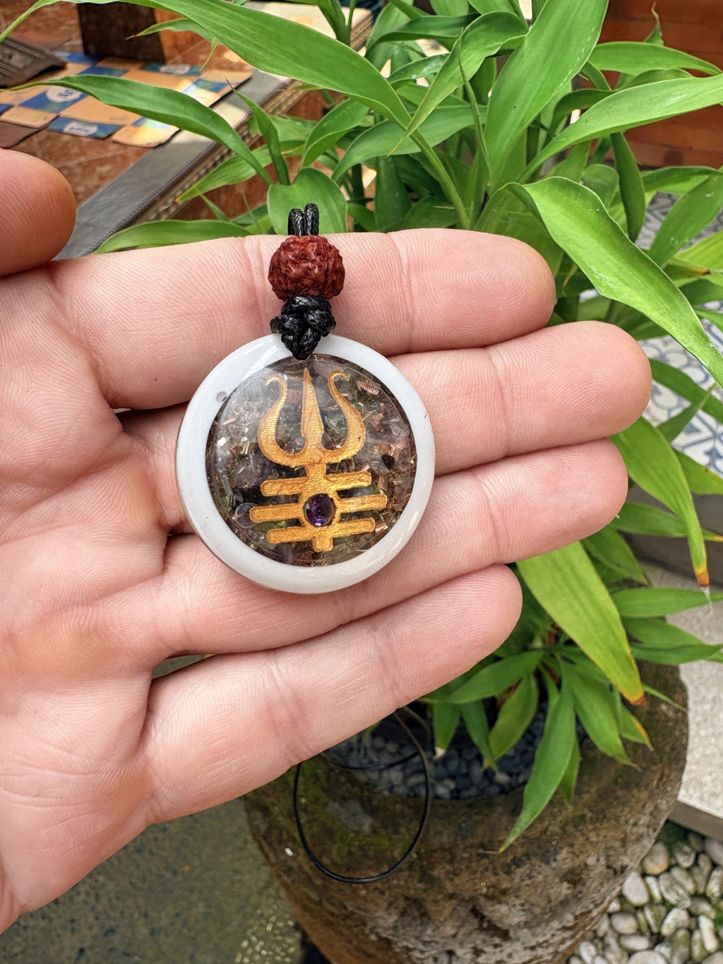 Shiva Trishula Pendant white resin frame gold Trishula Amethyst third eye cabochon mixed stone orgonite matrix Rudraksha bail black cord front view Batuan Bali