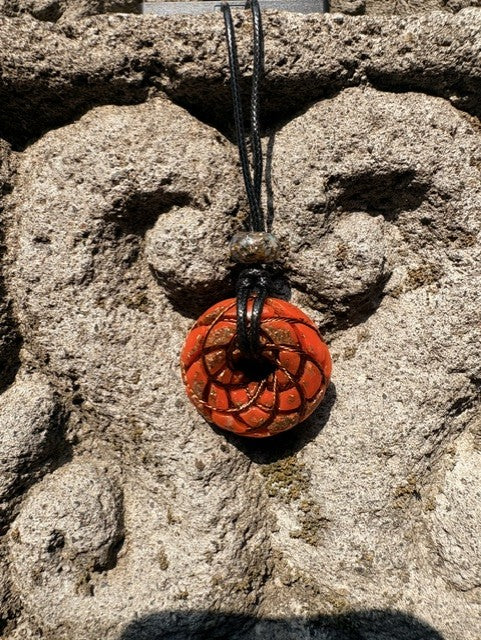 Small Red Jasper Torus Pendant copper spiral winding deep burnt orange red resin 33mm black braided cord stone bail bead Balinese stone wall Batuan Bali front view