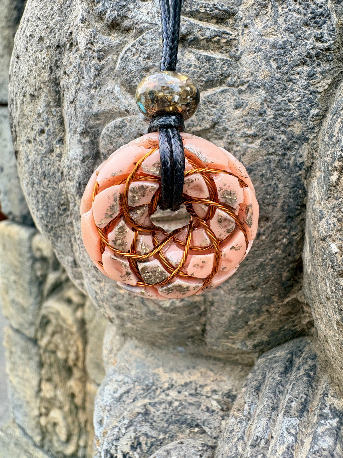 Rose Quartz Torus Pendant front view copper twisted wire torus coil soft peach pink Rose Quartz chunks silver gold metal leaf 33mm heart chakra worn on stone Batuan Bali