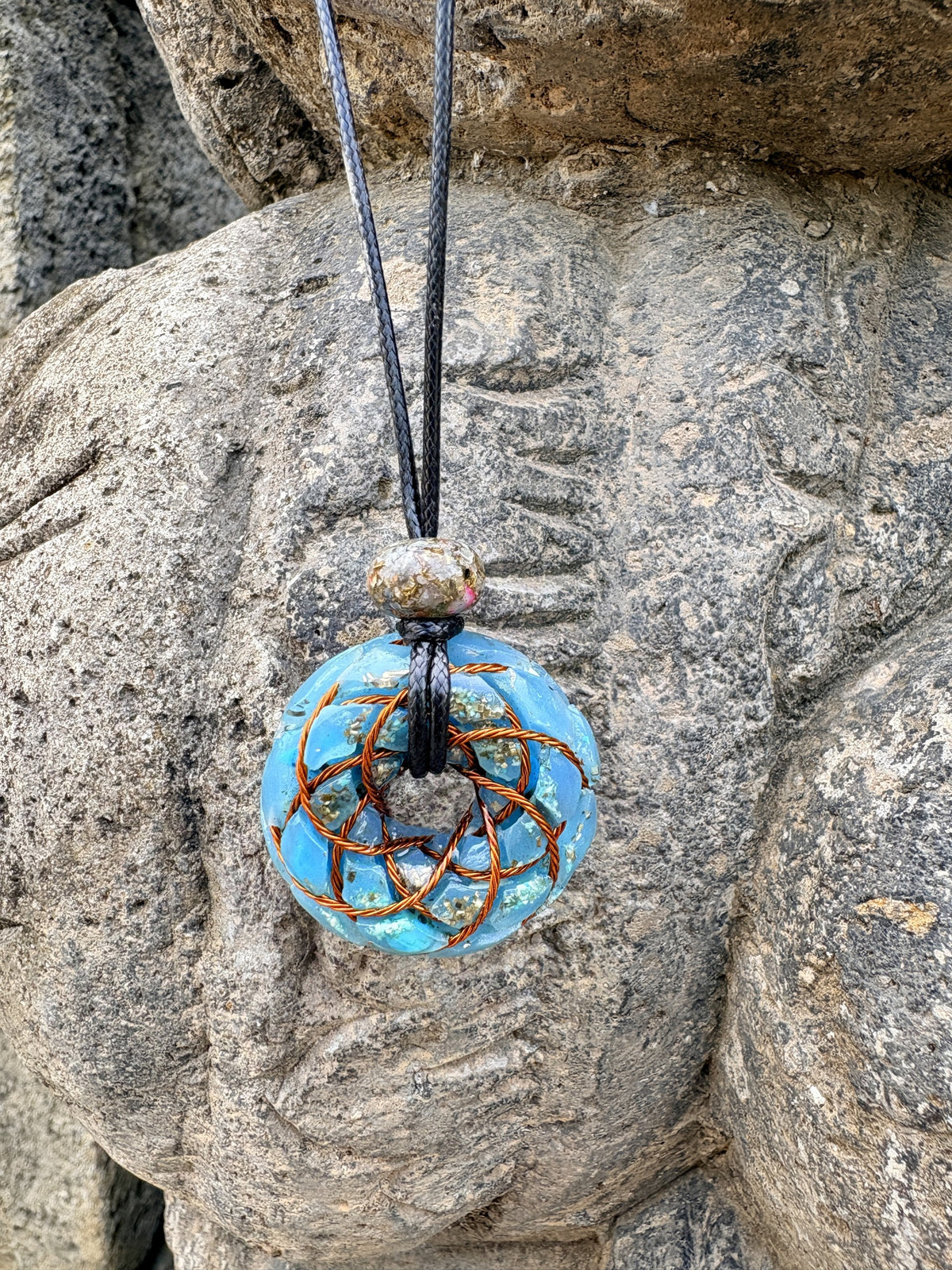 Turquoise Torus Pendant front view copper twisted wire torus coil vivid sky blue Turquoise chunks gold leaf orgonite 33mm worn on stone